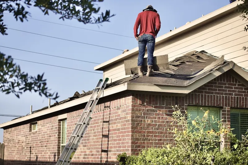 Professional roofer working on a residential roof in Idamar